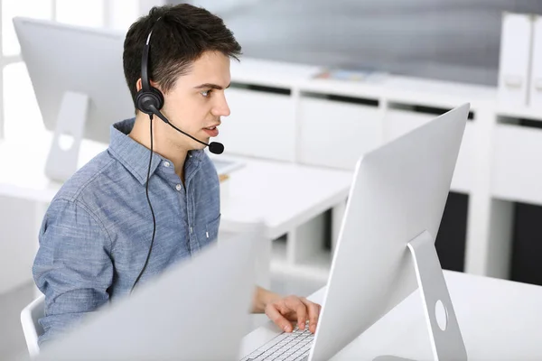 Grupo de operadores en el trabajo. Centro de llamadas. Concéntrate en la recepcionista joven en auriculares al servicio al cliente. Concepto de negocio y estilo de ropa casual —  Fotos de Stock