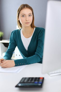 Muhasebeci mali durumu kontrol ediyor ya da vergi formları için hesap makinesi geliri ile sayıyor, eller yakın çekim. Ofisteki masada oturan ve çalışan bir iş kadını. Denetim kavramı