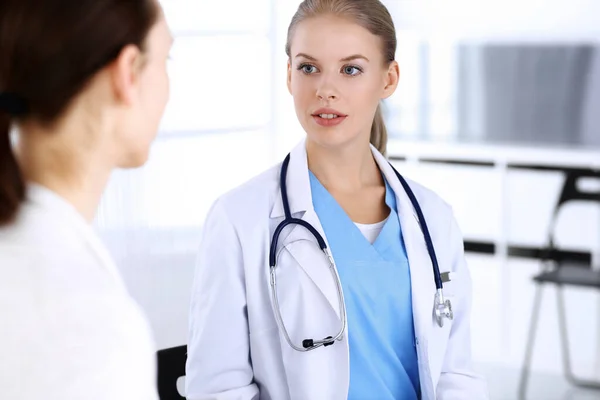 Doctor y paciente durante la consulta. Médico en el trabajo llenando el historial de medicamentos mientras está sentado en el hospital de emergencia, sesión de fotos. Concepto de medicina y salud — Foto de Stock