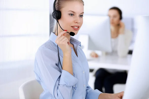 コールセンター事務所。オンラインでクライアントをコンサルティングするためのコンピュータとヘッドセットを使用して美しいブロンドの女性。顧客サービスの職業として働く事業者のグループ。ビジネス界の概念 — ストック写真