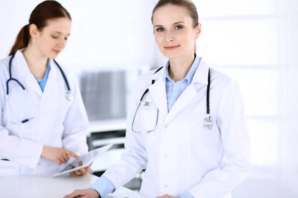 Grupo de médicos en el trabajo en el hospital. Médico llenando documentos médicos o receta mientras está de pie en la recepción. Datos en medicina y concepto de salud — Foto de Stock