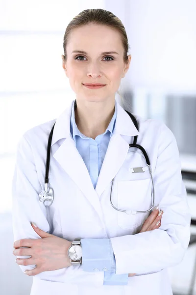 Doktorka v práci v nemocnici. Lékař stojí zpříma a usmívá se, studiový portrét. Koncepce medicíny a zdravotní péče — Stock fotografie