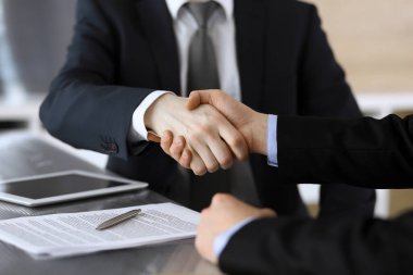 İş adamı, modern ofiste iş arkadaşı veya ortağıyla el sıkışıyor. Yakın plan. Toplantıda bilinmeyen iş adamları var. Takım çalışması, ortaklık ve el sıkışma kavramı