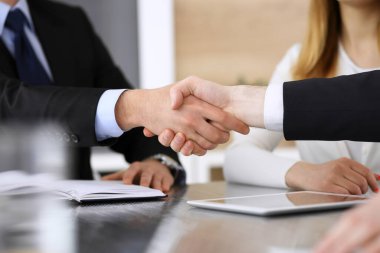 İş adamı, modern ofiste iş arkadaşı veya ortağıyla el sıkışıyor. Yakın plan. Toplantıda bilinmeyen iş adamları var. Takım çalışması, ortaklık ve el sıkışma kavramı