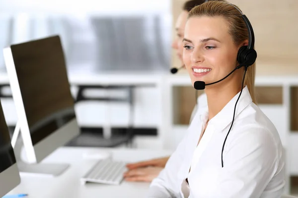 Volejte centrálu. Šťastné a vzrušené obchodní žena pomocí sluchátka při konzultaci klientů on-line. Oddělení zákaznického servisu nebo telemarketingu. Usmívající se skupina operátorů při práci — Stock fotografie