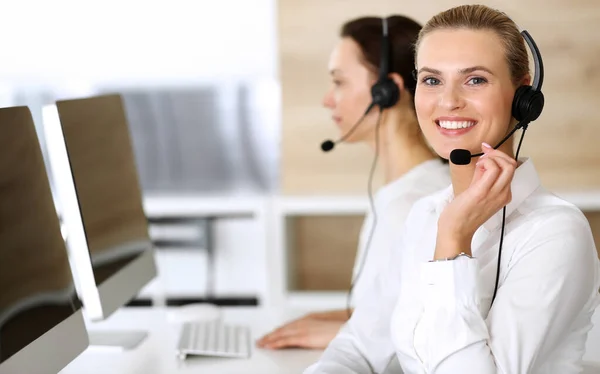 コールセンター。顧客をオンラインで相談しながらヘッドセットを使用して幸せと興奮のビジネス女性。カスタマーサービスオフィスまたはテレマーケティング部門。作業中の作業者の笑顔グループ — ストック写真