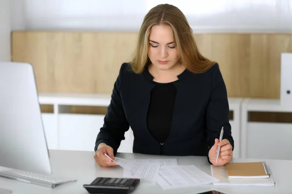 ブロンドのビジネス女性はオフィスでコンピュータと座って働いています。会計士と秘書が報告する。監査、税務サービスの概念 — ストック写真
