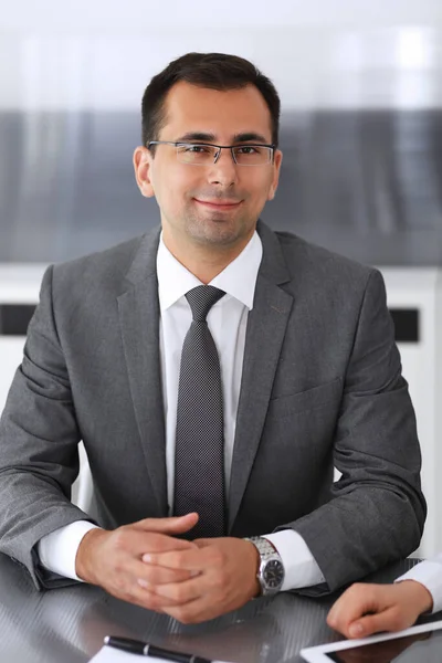 Homme d'affaires headshot à la réunion dans le bureau moderne. Entrepreneur assis à la table avec des collègues. Travail d'équipe et concept de partenariat. Costumes blazer gris au heureux gestionnaire souriant — Photo