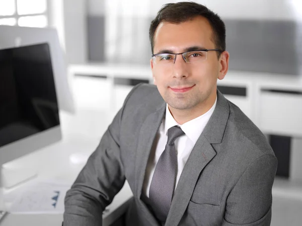 Homme d'affaires headshot à la réunion dans le bureau moderne. Entrepreneur assis à la table avec des collègues. Travail d'équipe et concept de partenariat. Costumes blazer gris au heureux gestionnaire souriant — Photo