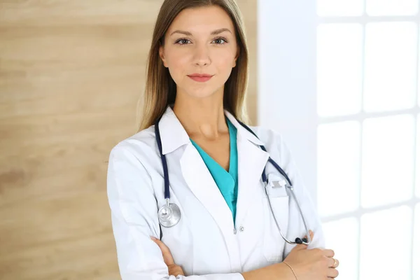 Doctora mujer de pie y mirando la cámara. Médico en el trabajo, retrato de estudio en el fondo médico. Concepto de medicina y salud — Foto de Stock