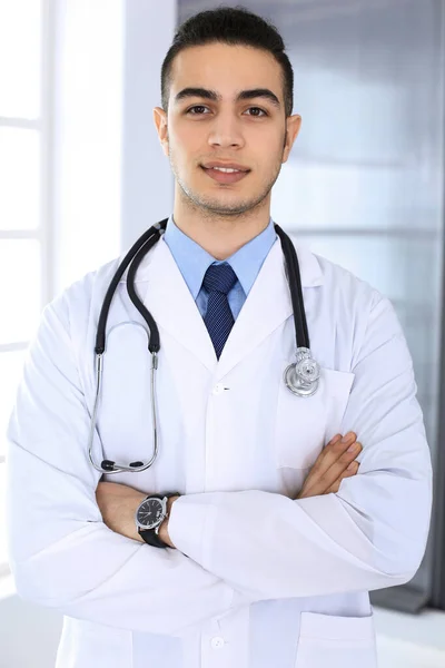 Homem médico árabe de pé com braços cruzados em consultório médico ou clínica. Conceito de medicina e saúde — Fotografia de Stock