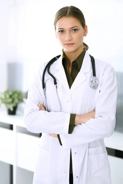 Doctora de pie recta y mirando a la cámara. Servicio médico perfecto en la clínica. Futuro feliz en medicina y salud — Foto de Stock