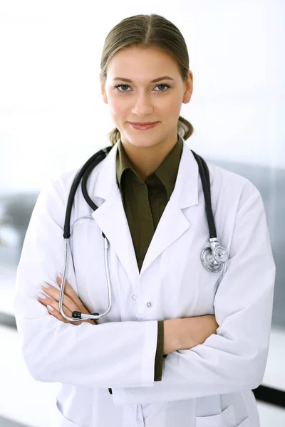 Doctora de pie recta y mirando a la cámara. Servicio médico perfecto en la clínica. Futuro feliz en medicina y salud — Foto de Stock