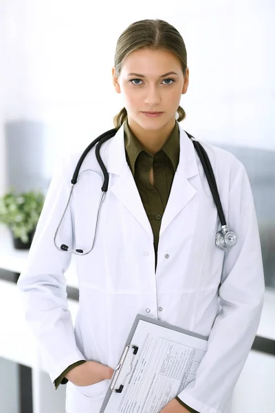 Doctora de pie recta y mirando a la cámara. Servicio médico perfecto en la clínica. Futuro feliz en medicina y salud — Foto de Stock