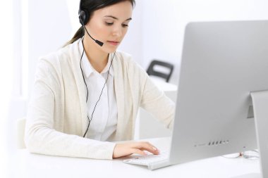 Merkezi ara. Müşteri hizmetleri ofisinde kulaklıkla oturan güzel bir kadın resepsiyonist. Bir grup operatör iş başında. İş konsepti