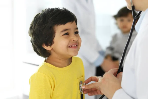 Médico examinando a un niño paciente por estetoscopio. Lindo chico árabe en la cita con el médico. Concepto de medicina y salud —  Fotos de Stock