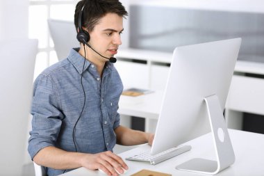 Bir grup operatör iş başında. Merkezi ara. Müşteri hizmetlerindeki genç resepsiyoniste odaklan. İş konsepti ve günlük giyim tarzı