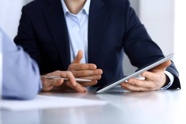 Modern ofiste birlikte çalışırken iş adamları tablet bilgisayar kullanıyorlar. İş yerinde iş arkadaşı olan tanınmamış bir iş adamı ya da erkek girişimci. Takım çalışması ve ortaklık kavramı