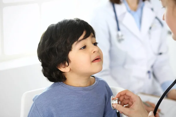 Az orvos sztetoszkóppal vizsgál meg egy gyermekbeteget. Aranyos arab fiú az orvosnál. Orvosi és egészségügyi koncepció — Stock Fotó