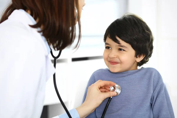 Médico examinando a un niño paciente por estetoscopio. Lindo chico árabe en la cita con el médico. Concepto de medicina y salud —  Fotos de Stock
