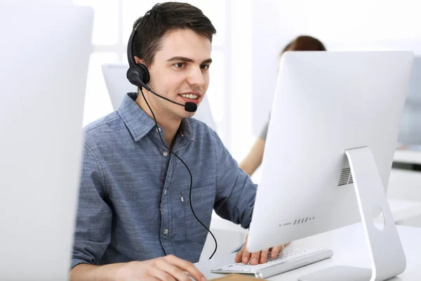 Grupo de operadores en el trabajo. Centro de llamadas. Concéntrate en la recepcionista joven en auriculares al servicio al cliente. Concepto de negocio y estilo de ropa casual —  Fotos de Stock