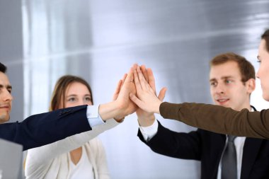 Takım çalışması yapan ve el ele tutuşan iş adamları grubu ya da modern ofiste kontrat imzaladıktan sonra beş kişi. Meslektaşları ya da avukatları olan tanınmamış işadamı ve kadın elleriyle daire çiziyor.