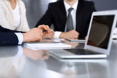 İş adamları modern ofisteki cam masasında birlikte çalışarak sözleşmeyi tartışıyor. İş arkadaşları ya da avukatları olan tanınmamış bir iş adamı ve kadın. Takım çalışması ve ortaklık