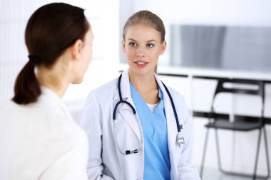 Muayene sırasında doktor ve hasta. Acil serviste portre çekimi yaparken ilaç geçmişini dolduran bir doktor. İlaç ve sağlık hizmetleri kavramı