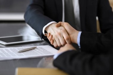 İş adamı, modern ofiste iş arkadaşı veya ortağıyla el sıkışıyor. Yakın plan. Toplantıda bilinmeyen iş adamları var. Takım çalışması, ortaklık ve el sıkışma kavramı