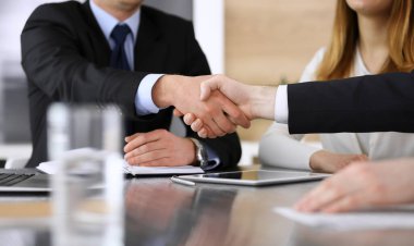 İş adamı, modern ofiste iş arkadaşı veya ortağıyla el sıkışıyor. Yakın plan. Toplantıda bilinmeyen iş adamları var. Takım çalışması, ortaklık ve el sıkışma kavramı