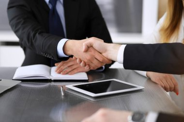 İş adamı, modern ofiste iş arkadaşı veya ortağıyla el sıkışıyor. Yakın plan. Toplantıda bilinmeyen iş adamları var. Takım çalışması, ortaklık ve el sıkışma kavramı