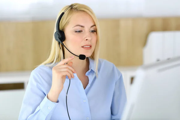 Samtalscentralen. Blond affärskvinna sitter i headset på kundtjänst kontor. Begreppet distansförsäljning företag eller hemmakontor yrke — Stockfoto