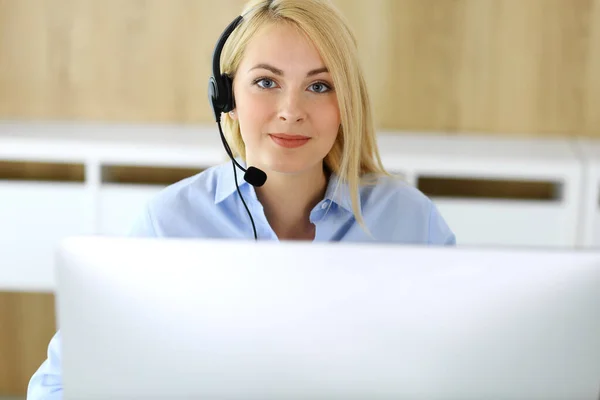 Call center. Blonde business woman sitting in headset at customer service office. Concept of telesales business or home office occupation Stock Picture