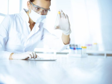 Kadın laboratuvar asistanı hastanede kan örneğini inceliyor. Tıp, sağlık ve araştırma konsepti