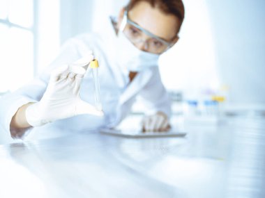 Kadın laboratuvar asistanı hastanede kan örneğini inceliyor. Tıp, sağlık ve araştırma konsepti