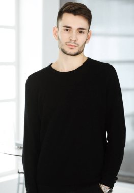 Modern ofiste sakallı adamın vesikalığı. İş adamı ya da öğrenci, dik durup gülümsüyor. Yaşam tarzı kavramı