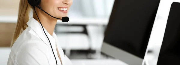 Unknown female customer service representative is consulting clients online using headset.close-up. Call center and business concept