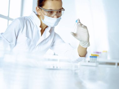 Kadın laboratuvar asistanı hastanede kan örneğini inceliyor. Tıp, sağlık ve araştırma konsepti