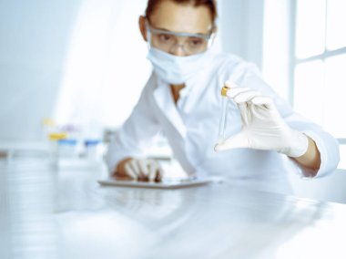 Kadın laboratuvar asistanı hastanede kan örneğini inceliyor. Tıp, sağlık ve araştırma konsepti