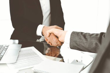 Bilinmeyen çeşitli iş adamları ofis masasındaki toplantıyı bitirmek için el sıkışıyorlar, yakın plan. El sıkışma kavramı