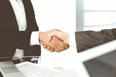 Bilinmeyen çeşitli iş adamları ofis masasındaki toplantıyı bitirmek için el sıkışıyorlar, yakın plan. El sıkışma kavramı