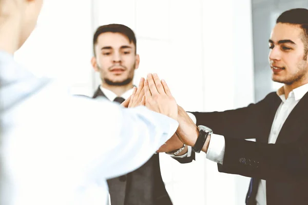 Группа деловых людей показывает командную работу, объединяет руки и дает друг другу пять в современном офисе. Концепция успеха — стоковое фото