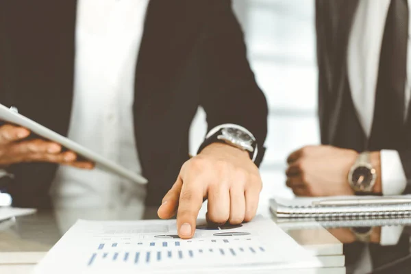 Gente de negocios que usa tableta mientras trabajan juntos en la oficina moderna. Hombre de negocios desconocido sentado en el escritorio con su colega o compañero. Trabajo en equipo y concepto de asociación —  Fotos de Stock