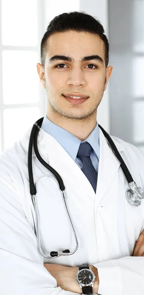Arabski lekarz stoi ze skrzyżowanymi ramionami w klinice. Koncepcja medycyny i opieki zdrowotnej — Zdjęcie stockowe