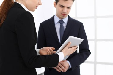 İşadamı ve kadın ofiste soruları tartışmak için tablet bilgisayar kullanıyorlar. Toplantının ortakları veya meslektaşları. İş birliği kavramı