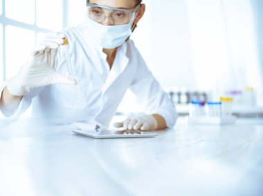 Kadın laboratuvar asistanı hastanede kan örneğini inceliyor. Tıp, sağlık ve araştırma konsepti