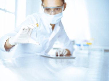 Kadın laboratuvar asistanı hastanede kan örneğini inceliyor. Tıp, sağlık ve araştırma konsepti