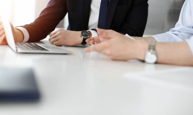 Bilinmeyen iş adamları modern ofisteki masada dizüstü bilgisayar kullanıyorlar. İş adamı ya da erkek girişimci meslektaşı ile birlikte çalışıyor. Takım çalışması ve ortaklık kavramı