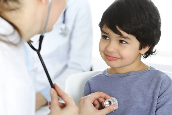 Lekarz-kobieta badający pacjenta za pomocą stetoskopu. Słodki arabski chłopiec na wizycie u lekarza. Koncepcja medycyny — Zdjęcie stockowe