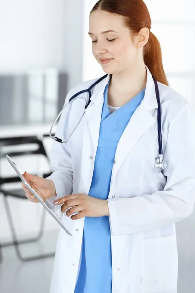Doctora o estudiante de prácticas en el trabajo. Médico femenino usando tableta mientras está de pie en la clínica. Concepto de medicina y salud — Foto de Stock